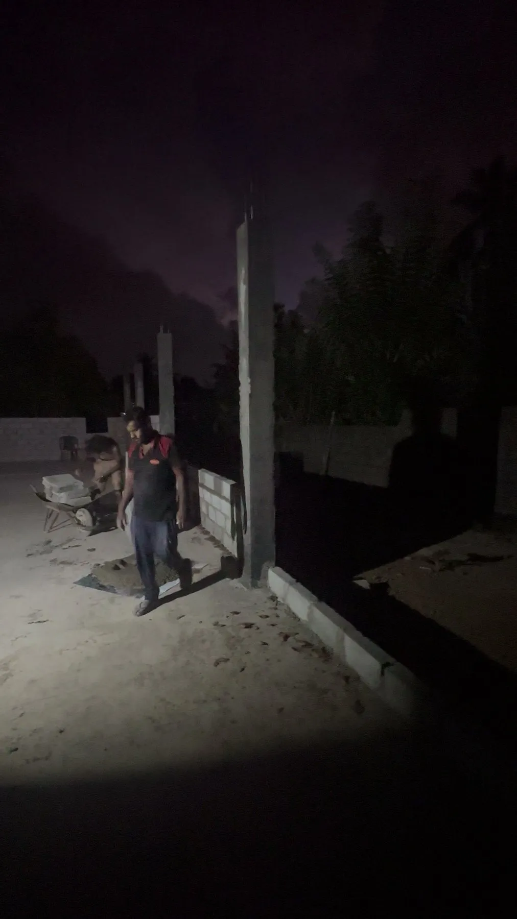 A mason laying blocks after dark
